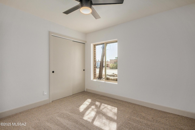 unfurnished bedroom with a closet, ceiling fan, baseboards, and carpet floors