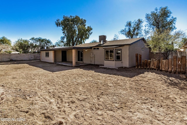 rear view of property with a fenced backyard, central AC, and a patio