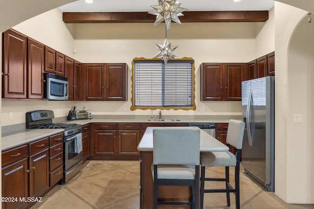 kitchen featuring light countertops, a breakfast bar, a sink, beamed ceiling, and appliances with stainless steel finishes