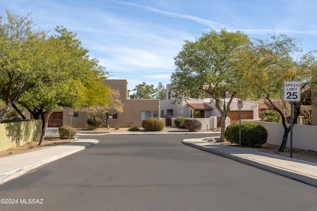 view of street featuring sidewalks, curbs, traffic signs, and a residential view