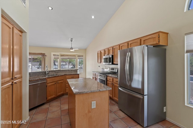 36973 S Highland Ridge Ct, Tucson, AZ 85739 - kitchen with stainless steel appliances, a kitchen island, dark stone counters, ceiling fan, and high vaulted ceiling
