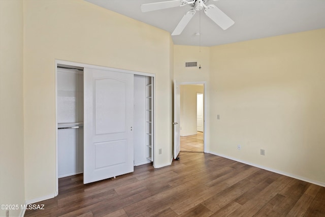 36973 S Highland Ridge Ct, Tucson, AZ 85739 - unfurnished bedroom with wood finished floors, a closet, baseboards, ceiling fan, and a towering ceiling