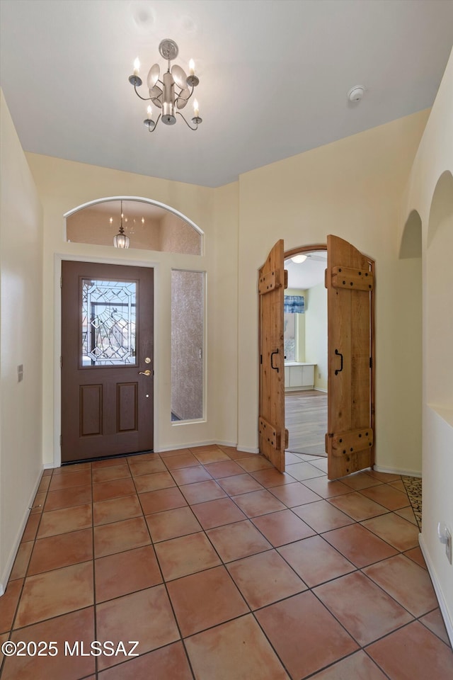 36973 S Highland Ridge Ct, Tucson, AZ 85739 - foyer with a chandelier, arched walkways, and light tile patterned floors