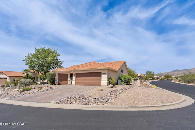 36973 S Highland Ridge Ct, Tucson, AZ 85739 - view of front of property featuring stucco siding, an attached garage, decorative driveway, a tiled roof, and a mountain view