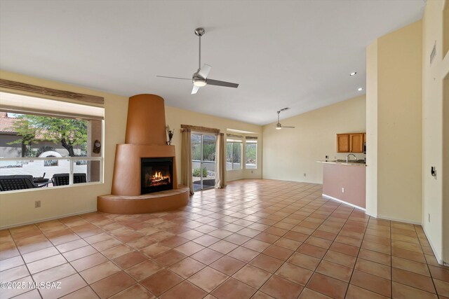 36973 S Highland Ridge Ct, Tucson, AZ 85739 - unfurnished living room featuring ceiling fan, lofted ceiling, a fireplace, a sink, and light tile patterned floors