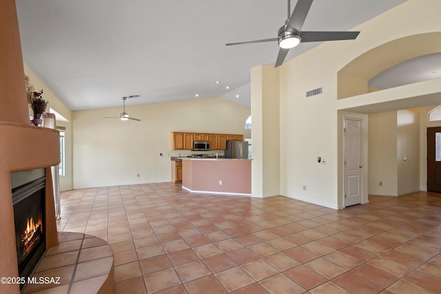 36973 S Highland Ridge Ct, Tucson, AZ 85739 - unfurnished living room featuring a ceiling fan, a warm lit fireplace, high vaulted ceiling, and light tile patterned floors