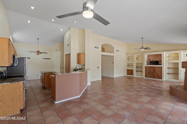 36973 S Highland Ridge Ct, Tucson, AZ 85739 - kitchen with ceiling fan, range, high vaulted ceiling, dark stone countertops, and arched walkways