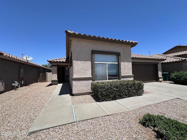 154 W Calle Patio Lindo, Sahuarita, AZ 85629 - mediterranean / spanish house featuring stucco siding, an attached garage, a tiled roof, and concrete driveway