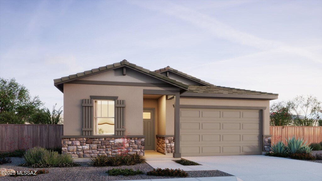 view of front of home featuring stone siding, stucco siding, driveway, and fence