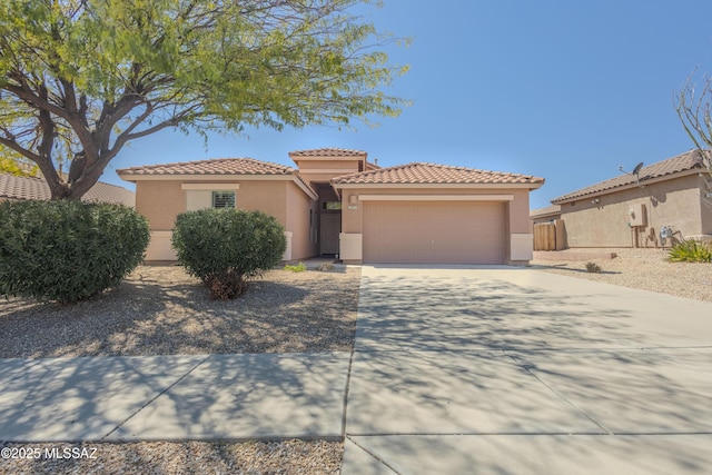 mediterranean / spanish-style home featuring a tile roof, a garage, driveway, and stucco siding