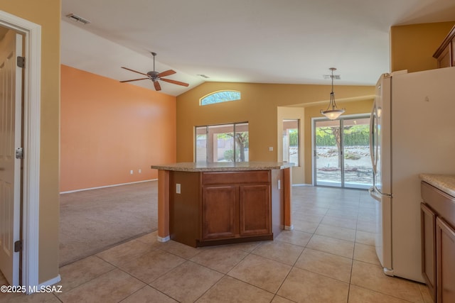 kitchen featuring freestanding refrigerator, plenty of natural light, light colored carpet, and visible vents