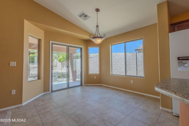unfurnished dining area featuring light tile patterned floors, plenty of natural light, vaulted ceiling, and visible vents