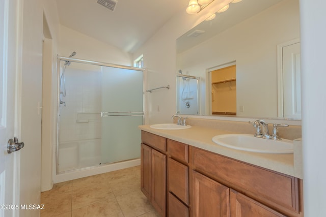 full bath featuring tile patterned floors, a sink, a shower stall, and visible vents