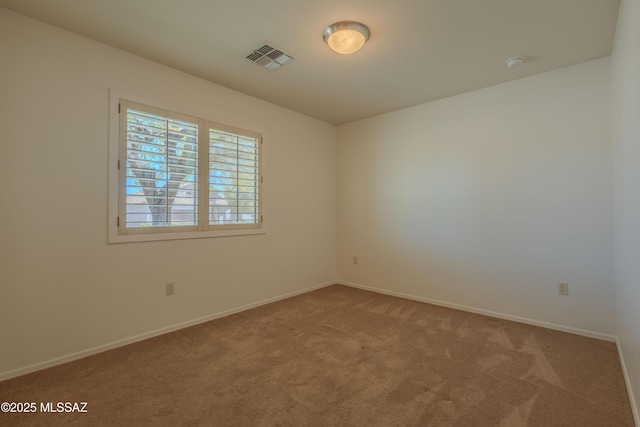 carpeted empty room featuring baseboards and visible vents