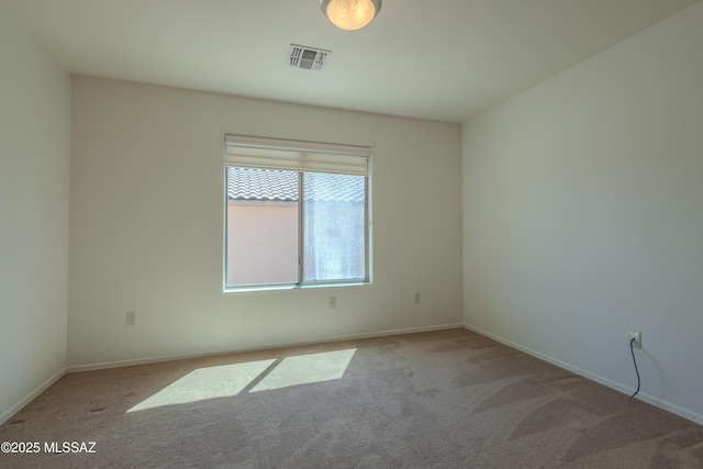 unfurnished room with baseboards, visible vents, and carpet