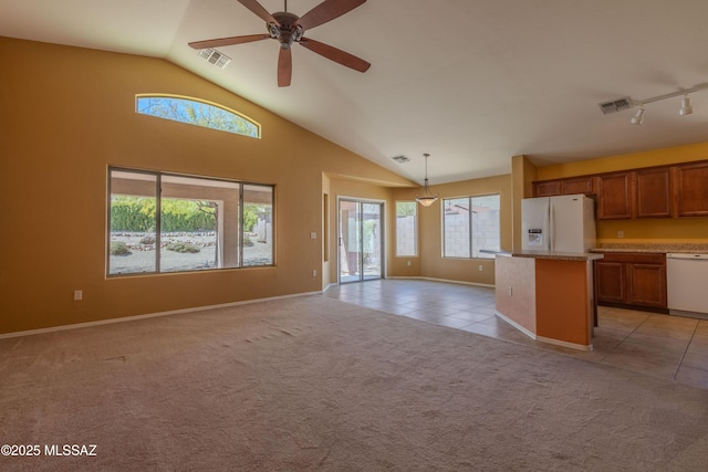 kitchen featuring a healthy amount of sunlight, light carpet, white appliances, and visible vents