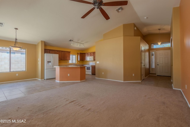 kitchen with open floor plan, visible vents, light carpet, and white appliances