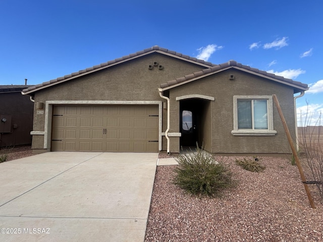 single story home with a tiled roof, stucco siding, driveway, and a garage