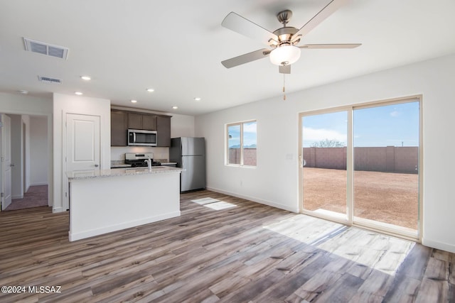 kitchen with visible vents, wood finished floors, a ceiling fan, and appliances with stainless steel finishes