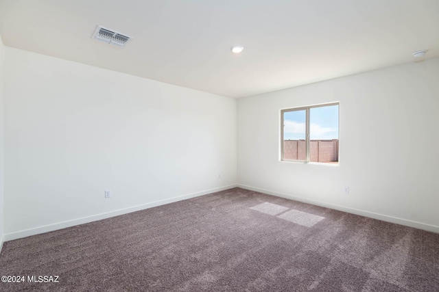 unfurnished room featuring baseboards, visible vents, and carpet