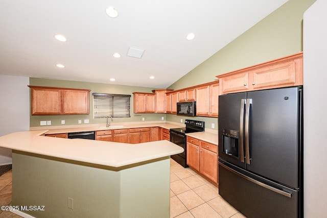 kitchen featuring light countertops, a peninsula, light tile patterned flooring, black appliances, and a sink