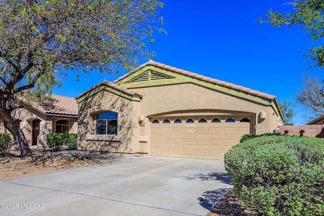 mediterranean / spanish house with concrete driveway, a tiled roof, a garage, and stucco siding