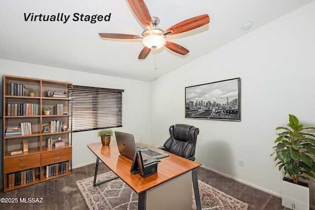 office area featuring baseboards, lofted ceiling, ceiling fan, and dark carpet