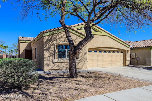 view of front of house featuring concrete driveway, a tiled roof, an attached garage, and stucco siding