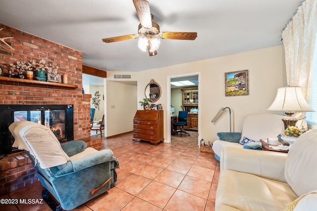 living area featuring visible vents, baseboards, ceiling fan, a fireplace, and light tile patterned flooring