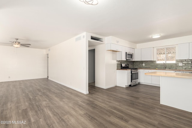 kitchen featuring visible vents, wooden counters, a sink, appliances with stainless steel finishes, and open floor plan