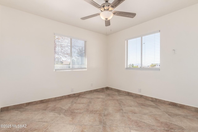 spare room with plenty of natural light, a ceiling fan, and baseboards