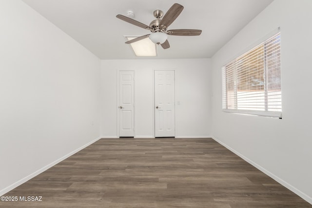 unfurnished bedroom with a ceiling fan, wood finished floors, and baseboards