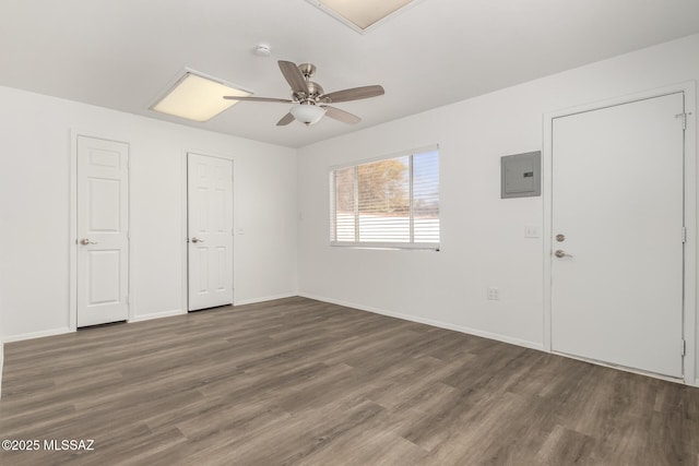 interior space with electric panel, baseboards, wood finished floors, and ceiling fan