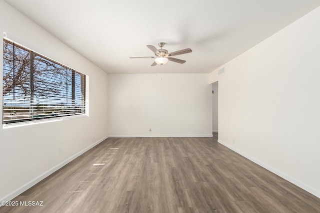 unfurnished room with visible vents, baseboards, a ceiling fan, and wood finished floors
