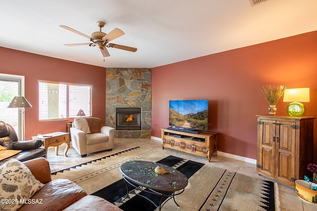 14938 N Gwynns Run Dr, Tucson, AZ 85739 - living area with ceiling fan, an accent wall, a fireplace, light tile patterned flooring, and baseboards
