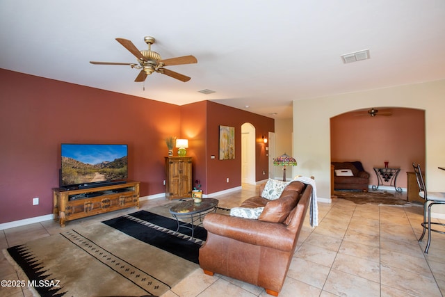 14938 N Gwynns Run Dr, Tucson, AZ 85739 - living room with arched walkways, ceiling fan, light tile patterned floors, and baseboards