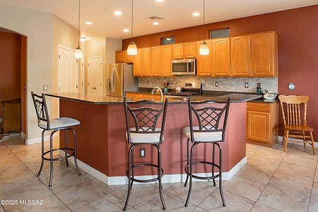 14938 N Gwynns Run Dr, Tucson, AZ 85739 - kitchen featuring stainless steel appliances, tasteful backsplash, an island with sink, a breakfast bar, and recessed lighting