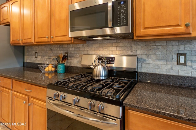 14938 N Gwynns Run Dr, Tucson, AZ 85739 - kitchen with stainless steel appliances, dark stone counters, tasteful backsplash, and brown cabinetry