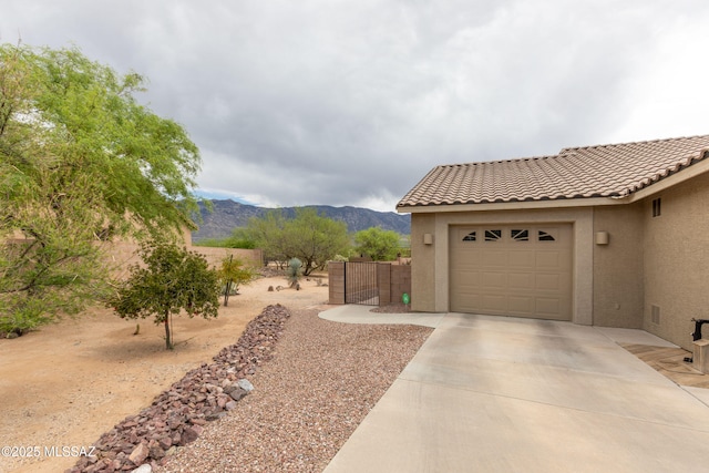 14938 N Gwynns Run Dr, Tucson, AZ 85739 - view of yard featuring a mountain view, driveway, and an attached garage