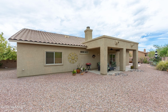 14938 N Gwynns Run Dr, Tucson, AZ 85739 - back of property featuring a ceiling fan, stucco siding, a patio, a chimney, and a tiled roof
