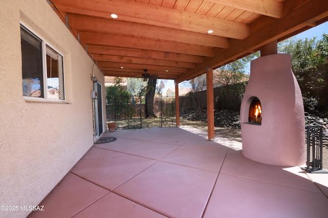view of patio / terrace with a lit fireplace and fence