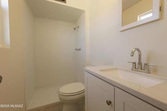 bathroom featuring vanity, toilet, and walk in shower