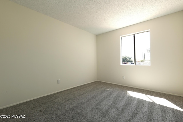 spare room featuring carpet flooring, a textured ceiling, and baseboards