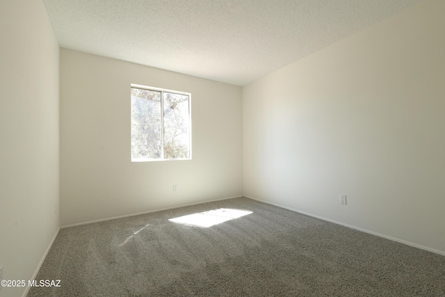 carpeted empty room with baseboards and a textured ceiling