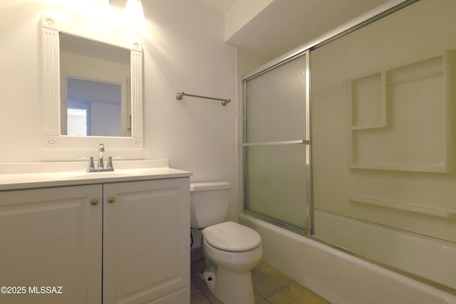 bathroom featuring tile patterned flooring, toilet, vanity, and shower / bath combination with glass door