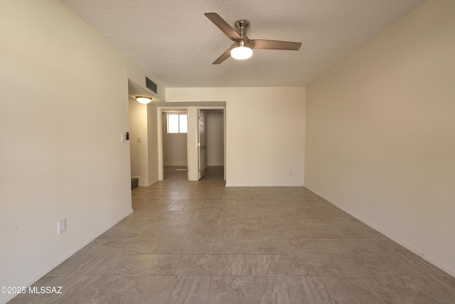 empty room with visible vents, a textured ceiling, and ceiling fan