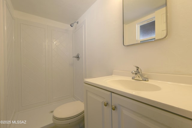bathroom with toilet, vanity, and a shower