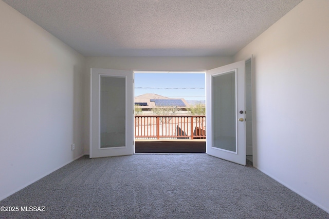 empty room with carpet floors and a textured ceiling