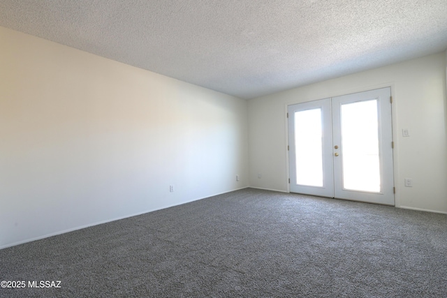 empty room with carpet flooring, french doors, and a textured ceiling