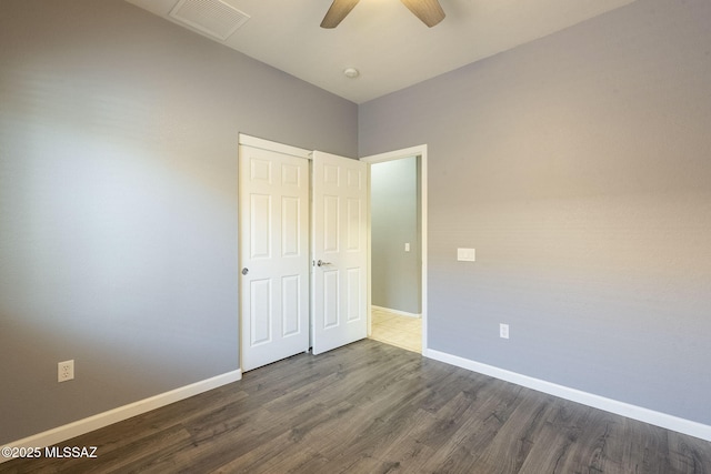 20868 E Treasure Rd, Red Rock, AZ 85145 - unfurnished bedroom with visible vents, baseboards, a ceiling fan, and dark wood-style flooring
